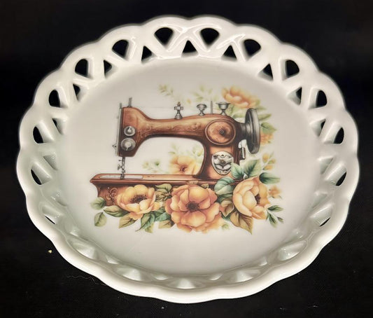 Decorative ceramic coaster with a sewing machine and floral design on a black background