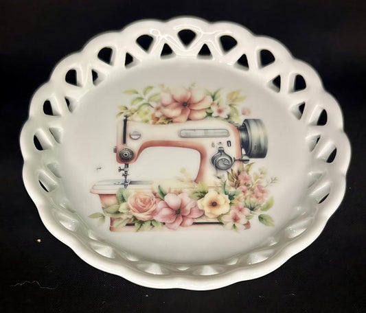 Decorative ceramic coaster with a sewing machine and floral design on a black background