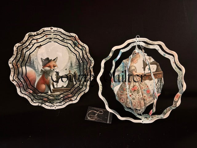 Courtly Quilter design with fox and sewing machine on one side, sewing fairy on other side of wind spinner